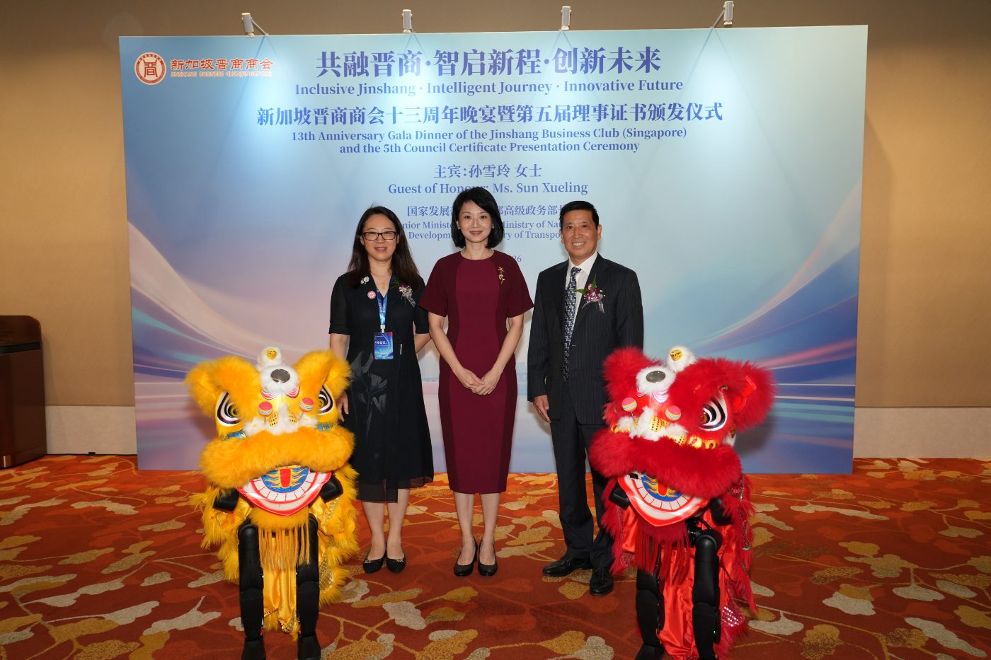 Two K1 robots in lion dance costumes stand in front of guests at a gala dinner